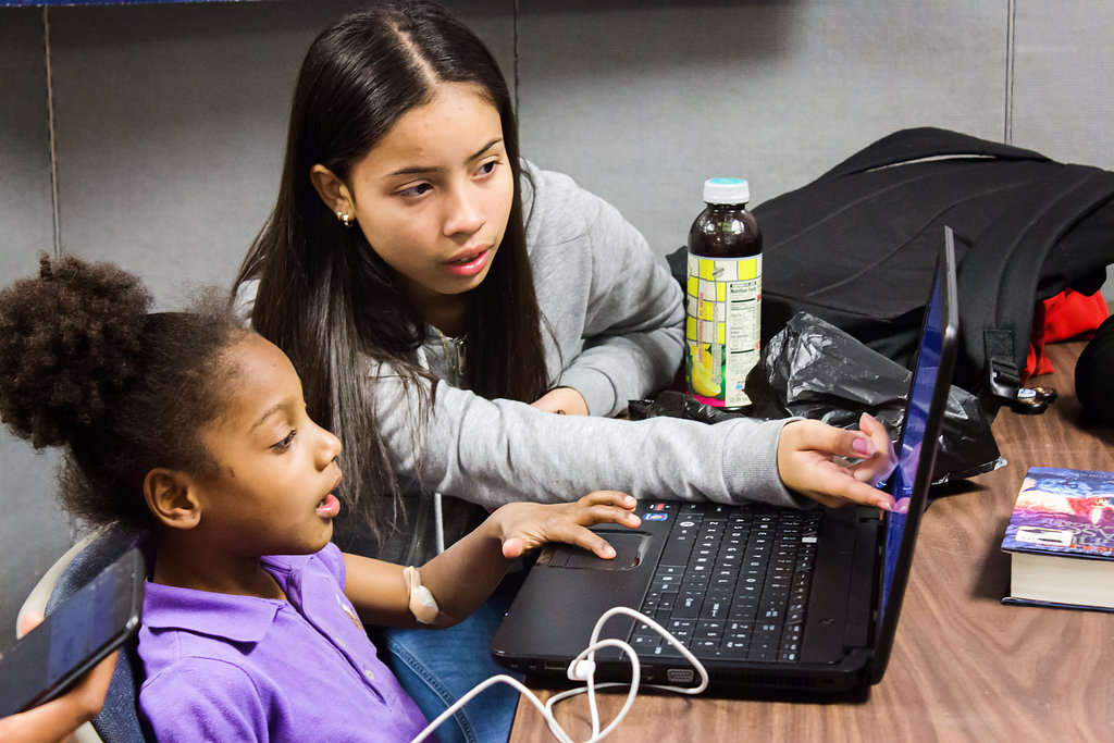 Kids use a computer together for homework